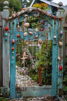 an old blue gate is decorated with seashells and beads