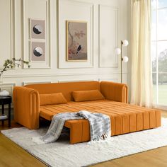 an orange couch sitting on top of a white rug