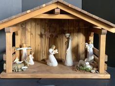 a wooden nativity scene with figurines in it