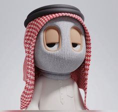 a close up of a doll wearing a hat and scarf on top of a head