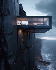 the house is built on top of a cliff overlooking the ocean and cliffs that surround it