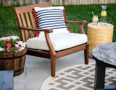 a chair and table sitting on a patio with potted flowers in the foreground