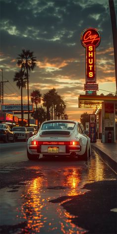 a white car parked in front of a neon sign on the side of a road