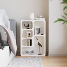 a white book shelf sitting on top of a wooden floor next to a bedroom bed