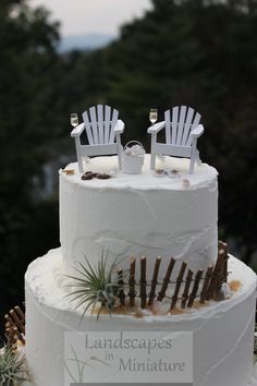 a wedding cake with two chairs on top