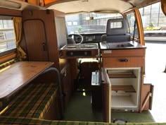 the interior of a camper with wood paneling and green carpeted flooring