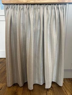 a kitchen counter with a wooden top and silver curtains