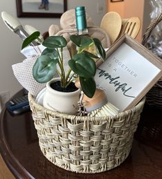 a basket filled with plants and other items on top of a wooden table next to a framed sign