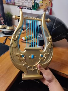 a golden harp with blue strings on top of a wooden desk