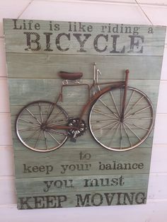 a wooden sign that says life is like riding a bicycle to keep your balance you must keep moving