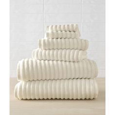 a stack of white towels sitting on top of a wooden table