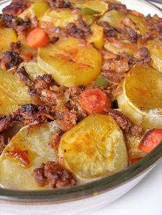 a glass dish filled with potatoes and meat