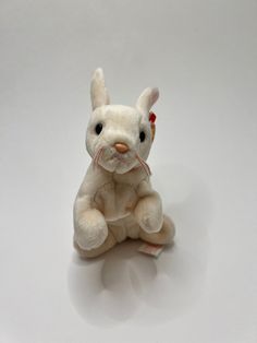 a white stuffed animal sitting on top of a table