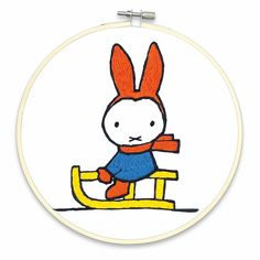 the embroidery pattern shows a rabbit sitting on a sled, with an orange scarf around its neck