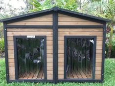 a dog house made out of wood and black metal bars on the sides, with two doors open