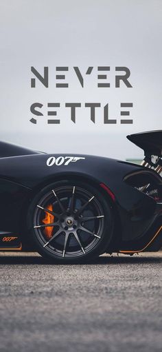 a black sports car sitting on top of a road next to the words never settle