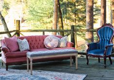 two chairs and a couch on a deck in front of some trees with a rug