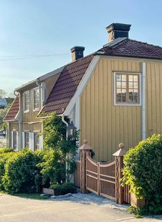 a house with a fence and bushes around it