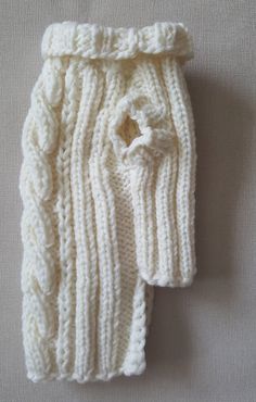 a white knitted scarf laying on top of a table