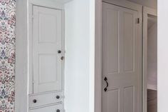 there are two doors in this room and one is white with floral wallpaper on the walls