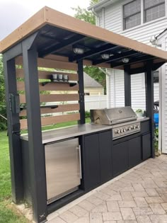 an outdoor kitchen with grill, sink and refrigerator