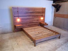 a wooden bed frame with two lights on each side