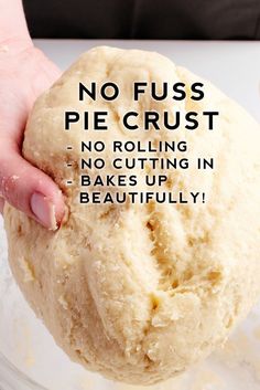 a person holding a ball of dough in their hand with the words no fuss pie crust on it