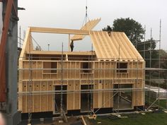 two men working on the roof of a house under construction with scaffolding around it