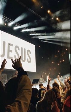 a large group of people standing on top of a stage with their hands in the air