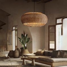 a living room filled with lots of furniture and a round light fixture hanging from the ceiling