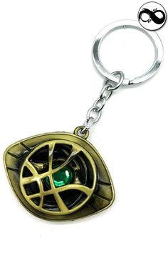 a metal keychain with a green eye in the shape of a wheel on it