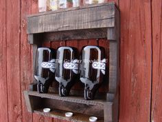 three empty beer bottles are sitting on a shelf in front of a red barn door