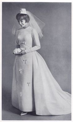 an old photo of a woman wearing a wedding dress and veil with crosses on it