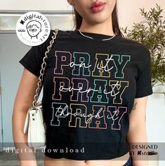 a woman wearing a black shirt with the words pray pray pray printed on it