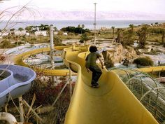 a man is standing on the edge of a water slide