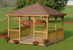 a wooden gazebo sitting on top of a lush green field