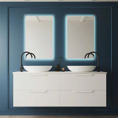 two white sinks sitting under mirrors in a room with blue walls and wooden flooring