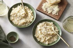 two green bowls filled with rice and topped with grated parmesan cheese