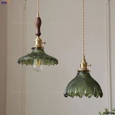 two green glass lights hanging from a ceiling