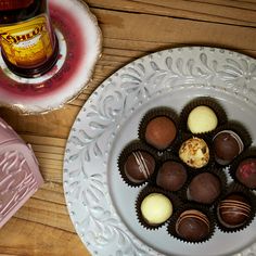 chocolates are arranged on a plate next to a bottle of beer