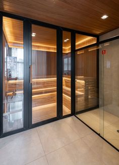 an indoor sauna room with glass doors and wood paneling on the walls,