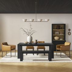 a dining room table with four chairs and a vase on the table in front of it