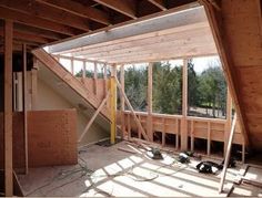 the interior of a house being built with wooden framing and windows on each side of the room