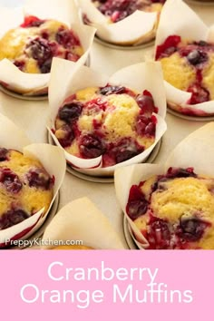 several muffins with blueberries and cranberry sauce in paper wrappers