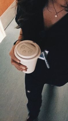 a woman holding a cup of coffee in her right hand