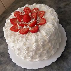 a cake with white frosting and strawberries on top