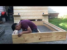 a man is bending over in a wooden box