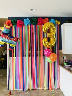 a birthday decoration with balloons and streamers in the shape of number eight on a wall