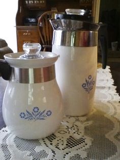 two white pitchers sitting on top of a table