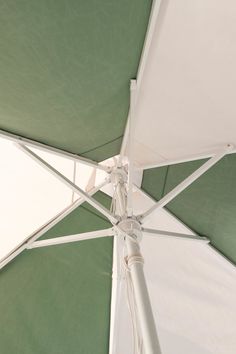 an open umbrella with green and white stripes on it's sides is seen from below